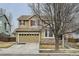 Inviting two-story home with a well-maintained lawn, stone accents, and a two-car garage at 17611 E 104Th Pl, Commerce City, CO 80022