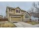 Charming two-story home with a two-car garage, stone accents, and well-maintained landscaping at 17611 E 104Th Pl, Commerce City, CO 80022