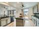 Open kitchen layout with a central island, stainless steel dishwasher, and sliding glass doors to the backyard at 17611 E 104Th Pl, Commerce City, CO 80022