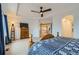 Main bedroom featuring large windows, tray ceiling, ceiling fan and a wooden bed frame, dresser at 17611 E 104Th Pl, Commerce City, CO 80022