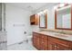 Bathroom featuring double sink vanity with granite countertop, walk-in shower, and modern fixtures at 11254 E Colorado Dr, Aurora, CO 80012