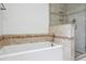 Clean bathroom featuring a soaking tub and tiled shower with glass door at 11254 E Colorado Dr, Aurora, CO 80012