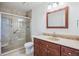 Well-lit bathroom featuring a glass shower, neutral tile, and wood vanity with a stone countertop at 11254 E Colorado Dr, Aurora, CO 80012