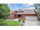 Charming brick home featuring a well-manicured lawn, mature trees, and an attached two car garage at 11254 E Colorado Dr, Aurora, CO 80012