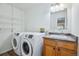 Functional laundry room with modern washer/dryer units and ample storage shelving at 11254 E Colorado Dr, Aurora, CO 80012