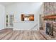 Open living room showcasing a brick fireplace, hardwood floors, and open access to the kitchen at 11254 E Colorado Dr, Aurora, CO 80012