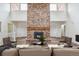 Living Room showcasing a brick fireplace and modern furnishings, complete with hardwood flooring at 11254 E Colorado Dr, Aurora, CO 80012