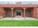 Covered patio with brick columns, a red pergola, and a brick facade at 11254 E Colorado Dr, Aurora, CO 80012