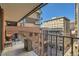 Apartment balcony with patio furniture, plants and a view of neighborhood buildings at 1551 Larimer St # 704, Denver, CO 80202