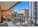 Balcony view of a brick-walled patio, with a chair, overlooking a modern city landscape at 1551 Larimer St # 704, Denver, CO 80202