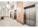 View of modern elevators, light fixtures and tile flooring in a common lobby area at 1551 Larimer St # 704, Denver, CO 80202