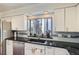 Modern kitchen with stainless steel appliances, black granite countertops, and a window above the sink at 1551 Larimer St # 704, Denver, CO 80202