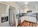 Modern kitchen with stainless steel appliances, white cabinetry, black countertops, and hardwood floors at 1551 Larimer St # 704, Denver, CO 80202