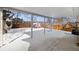 Covered backyard patio with snow-covered ground and surrounding fence, with a greenhouse in the background at 12843 W Jewell Cir, Lakewood, CO 80228