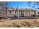 Back of house with a covered patio that offers a shaded outdoor space and yard with mature trees at 12843 W Jewell Cir, Lakewood, CO 80228