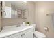 Bathroom featuring a white vanity, mirror, toilet, plants and neutral walls at 12843 W Jewell Cir, Lakewood, CO 80228