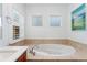 Bright bathroom featuring a standalone tub, tile surround, and frosted glass windows at 10618 Clearview Ln, Highlands Ranch, CO 80126