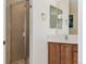 Modern bathroom featuring a glass shower, wood vanity with countertop, and square mirrors above sink at 10618 Clearview Ln, Highlands Ranch, CO 80126