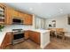 An open-concept kitchen with stainless steel appliances, wood cabinets, and a cozy dining area at 10618 Clearview Ln, Highlands Ranch, CO 80126