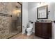 Modern bathroom features a stone tiled shower and wood look tile floors, plus granite vanity at 10640 Winding Pine Pt, Highlands Ranch, CO 80126