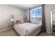 Bedroom featuring a tufted headboard bed and a scenic view through the windows at 10640 Winding Pine Pt, Highlands Ranch, CO 80126