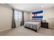 Cozy bedroom with bed, Colorado flag, and natural light from the window at 10640 Winding Pine Pt, Highlands Ranch, CO 80126