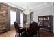 Elegant dining room featuring a chandelier, wood floors, brick wall and plenty of room for entertaining at 10640 Winding Pine Pt, Highlands Ranch, CO 80126