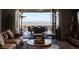 A cozy living room featuring hardwood floors, a ceiling fan, and glass doors leading to the outdoor deck with mountain views at 10640 Winding Pine Pt, Highlands Ranch, CO 80126