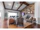 Inviting living room featuring exposed ceiling beams, stone fireplace, and seamless access to an outdoor patio with mountain views at 10640 Winding Pine Pt, Highlands Ranch, CO 80126