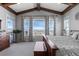 A spacious bedroom with exposed beams, mountain view windows, and an adjacent outdoor access door at 10640 Winding Pine Pt, Highlands Ranch, CO 80126