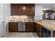 Basement wet bar featuring wooden cabinets, granite counters and stainless steel appliances at 10640 Winding Pine Pt, Highlands Ranch, CO 80126