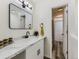 Bright bathroom featuring a modern vanity with a white countertop, black hardware, and a framed mirror at 12172 E Kepner Pl, Aurora, CO 80012