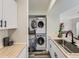 Efficient laundry area with stacked washer and dryer units and butcher block countertops at 12172 E Kepner Pl, Aurora, CO 80012