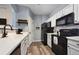 Modern kitchen with white cabinets, black appliances, and quartz countertops at 5255 Memphis St # 207, Denver, CO 80239