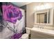 A well-lit bathroom featuring a sleek vanity, and a shower with decorative purple floral curtain at 10050 Holland Ct, Broomfield, CO 80021