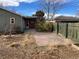 Backyard view showcasing a patio, mature trees, and a fenced area at 3044 Eudora St, Denver, CO 80207