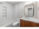 Modern bathroom featuring a tub with hexagon tiled walls and a stylish wood vanity with white countertop at 6960 S Knolls Way, Centennial, CO 80122