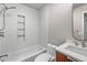 Modern bathroom featuring a tub with shower and hexagon tiled walls, with a stylish wood vanity at 6960 S Knolls Way, Centennial, CO 80122