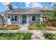 Charming single-Gathering home showcasing beautiful curb appeal with well-manicured lawn, flower pots, and a cozy covered porch at 6960 S Knolls Way, Centennial, CO 80122