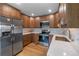 Bright kitchen featuring stainless steel appliances, wood cabinets, white countertops, and modern backsplash at 6960 S Knolls Way, Centennial, CO 80122