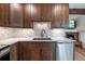 Modern kitchen features dark wood cabinetry, white countertops, mosaic backsplash, and stainless steel appliances at 6960 S Knolls Way, Centennial, CO 80122
