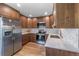 Bright kitchen featuring stainless steel appliances, wood cabinets, white countertops, and modern backsplash at 6960 S Knolls Way, Centennial, CO 80122