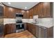 Bright kitchen featuring stainless steel appliances, wood cabinets, white countertops, and modern backsplash at 6960 S Knolls Way, Centennial, CO 80122