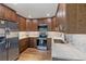 Well-lit kitchen featuring stainless steel appliances, wood cabinets, white countertop and hexagonal backsplash at 6960 S Knolls Way, Centennial, CO 80122