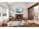 Inviting living room featuring a brick fireplace, hardwood floors, vaulted ceiling, and abundant natural light at 6960 S Knolls Way, Centennial, CO 80122