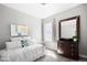 Cozy bedroom featuring a daybed with decorative pillows, dresser with mirror and plenty of natural light at 5450 Uinta St, Denver, CO 80238