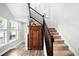 Elegant foyer with staircase, wood floors, and antique cabinet at 5450 Uinta St, Denver, CO 80238