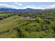 Aerial shot of a neighborhood with lush greenery and mountain views on a clear day at 12420 W Atlantic Ave, Lakewood, CO 80228