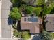 Aerial view of a home with solar panels, manicured landscaping, gardens, and mature trees at 12420 W Atlantic Ave, Lakewood, CO 80228
