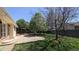 Spacious backyard featuring a concrete patio, grassy lawn, wooden fence, and mature trees at 12420 W Atlantic Ave, Lakewood, CO 80228